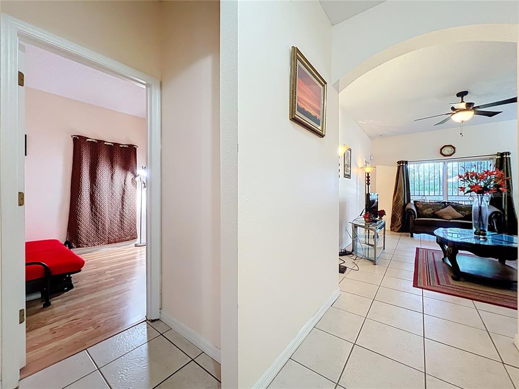A hallway leads to a living room with tile floors and a separate bedroom area — 4687 WESTGROVE WAY, ORLANDO, FL