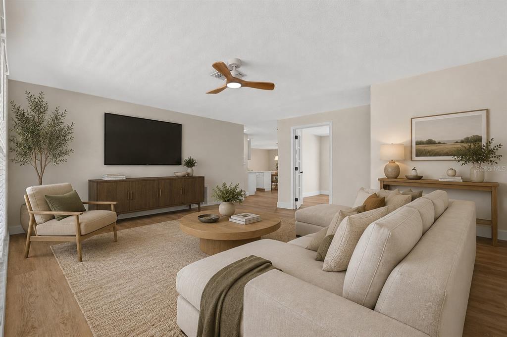 A living room features a beige sectional sofa, a round coffee table, and a television console — 7604 JASMINE BOULEVARD, PORT RICHEY, FL