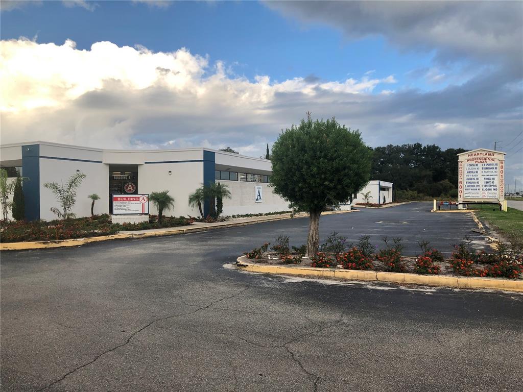 A low-rise commercial building with a parking lot and a directory sign in the foreground — 6801 US 27 HIGHWAY N UNIT C-3, SEBRING, FL