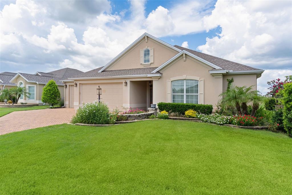 A paved driveway leads to a two-car garage at the front of a suburban house — 3452 BOSIE RUN, THE VILLAGES, FL