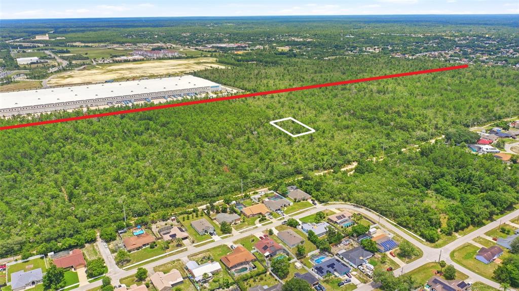 An aerial view shows a wooded lot marked with a white outline near residential homes — EDGEMONT (PAPER) AVENUE, DELTONA, FL