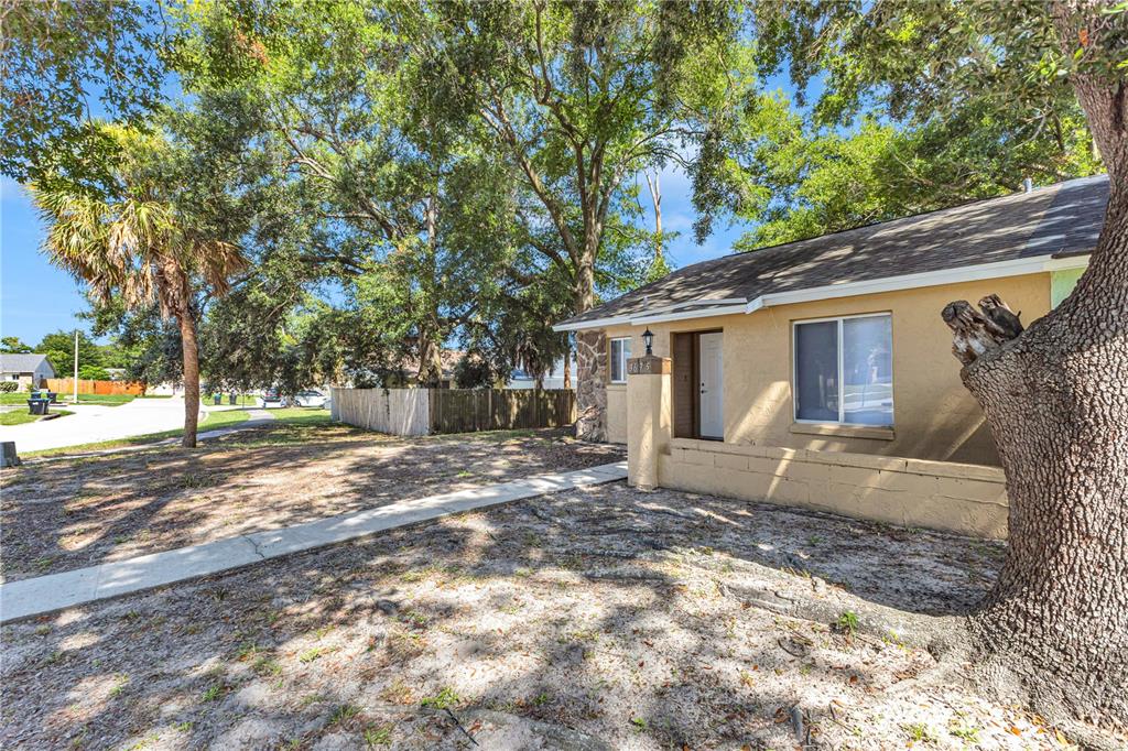 A tan house with a concrete walkway and large trees in the front yard — 3675 WESTLAND COURT, ORLANDO, FL