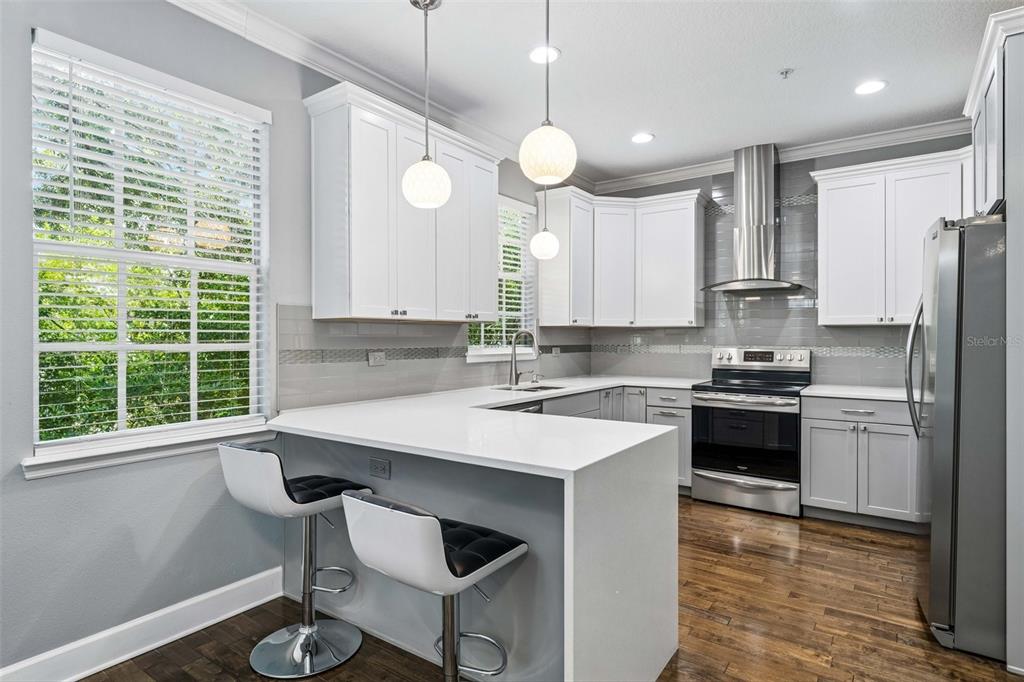 An entryway features a white door, a staircase with dark treads, and white marble flooring — 2613 ESPANA COURT, TAMPA, FL