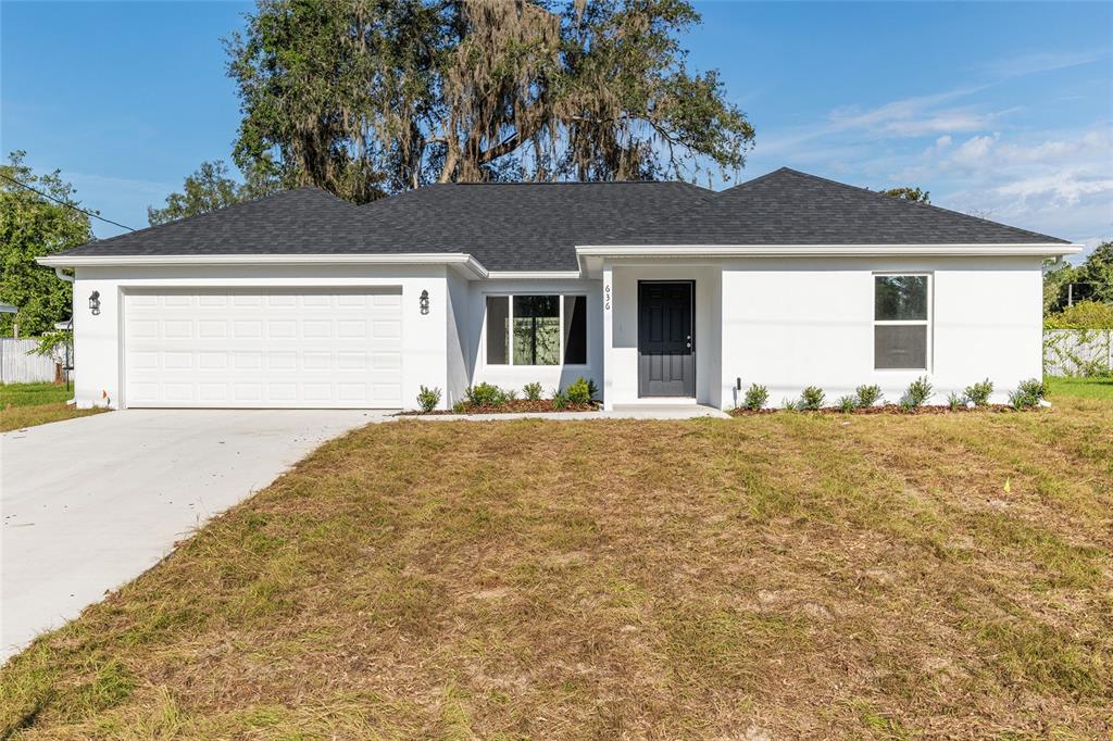 A bedroom with light wood-look flooring, a tray ceiling with a fan, and sliding doors — 6349 SW 153RD LANE ROAD, OCALA, FL
