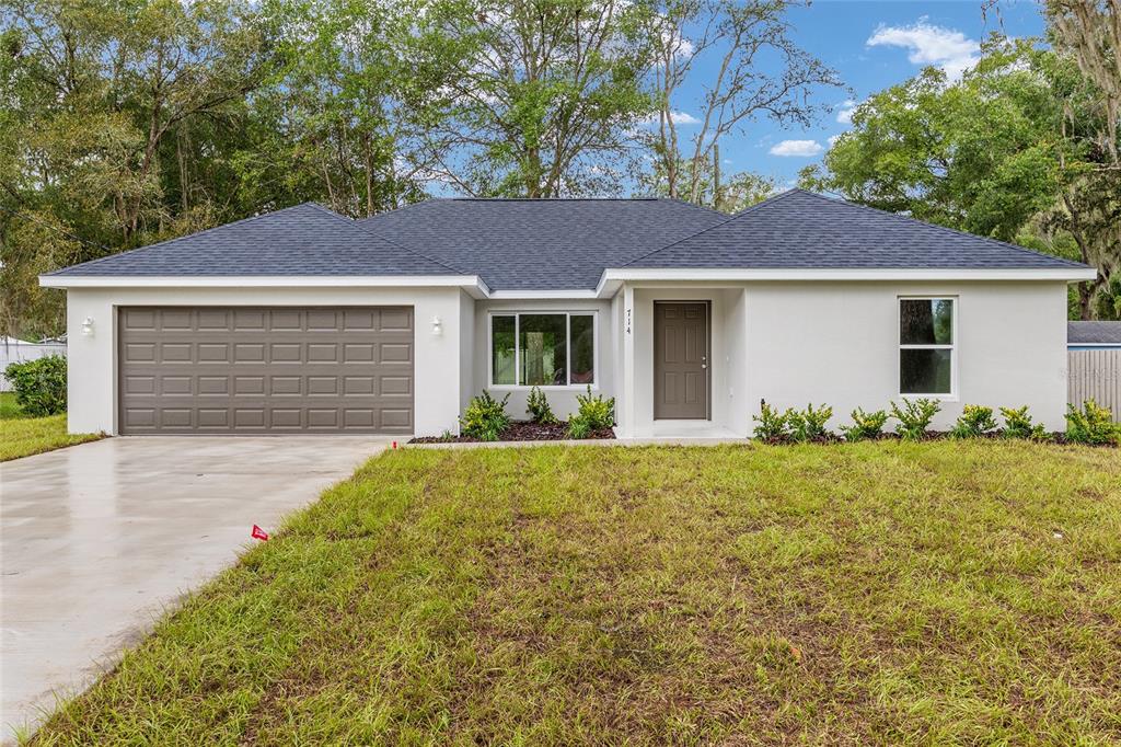 A bedroom with light wood-look flooring, a tray ceiling with a fan, and an attached bathroom — 6349 SW 153RD LANE ROAD, OCALA, FL