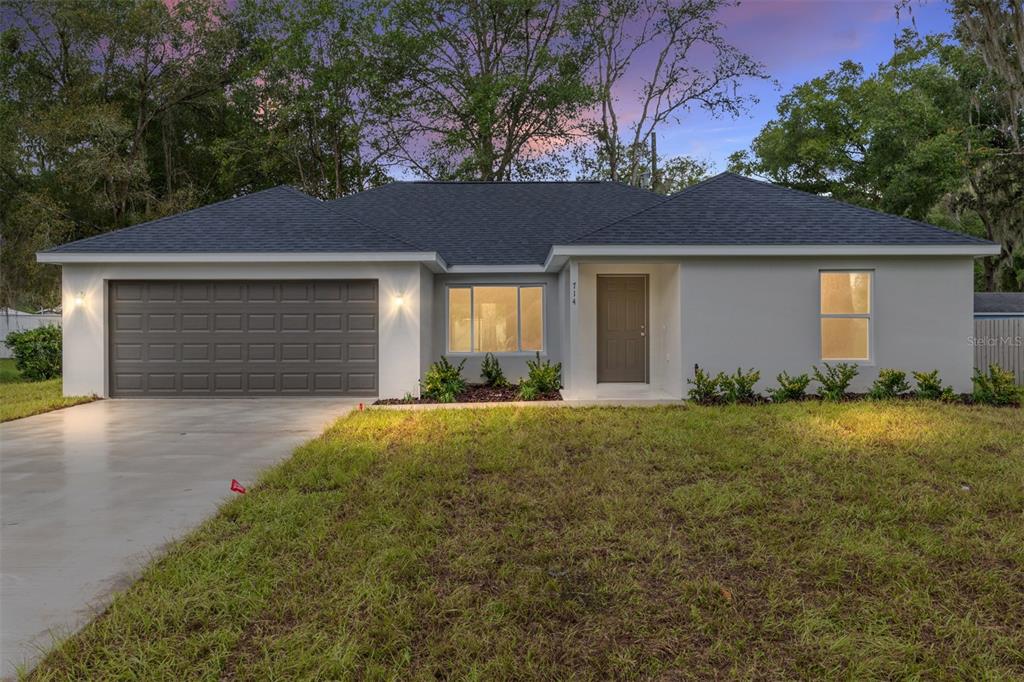 A bedroom with light gray walls, wood-look flooring, a tray ceiling, and a ceiling fan — 6349 SW 153RD LANE ROAD, OCALA, FL