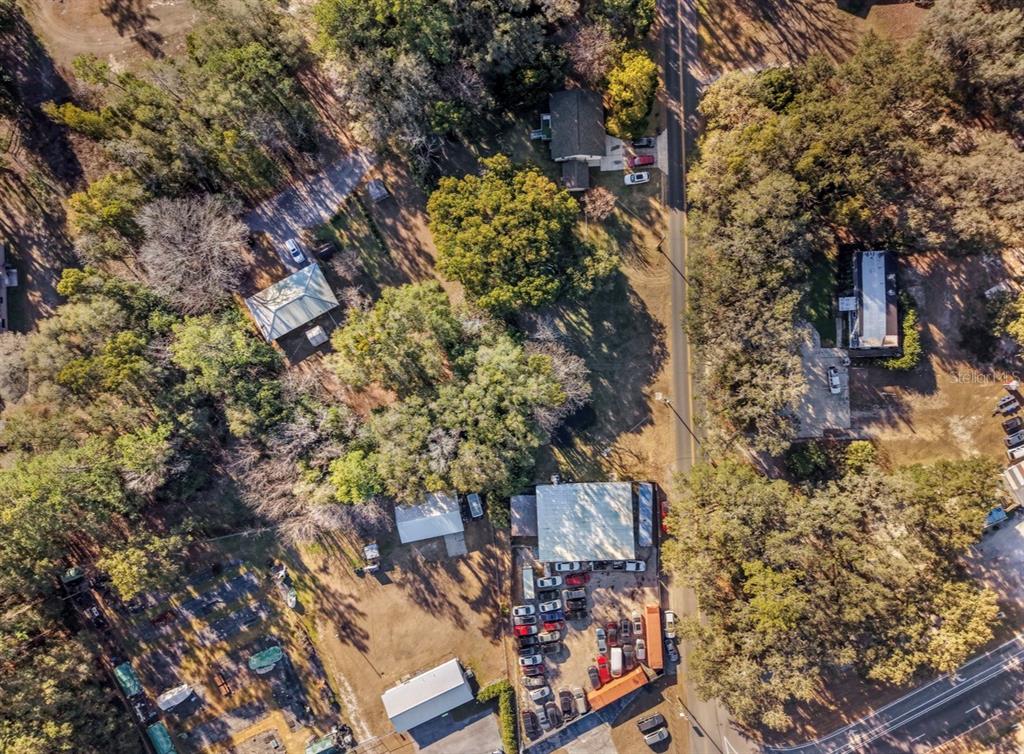 An aerial view shows a commercial building with a flat roof, parking lot, and vehicles — 2310 SE 59TH STREET, OCALA, FL
