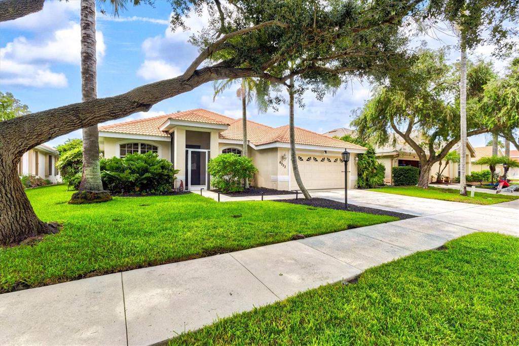 A view of a house exterior with a lamp post, palm trees, and walkway — 6252 DONNINGTON COURT, SARASOTA, FL