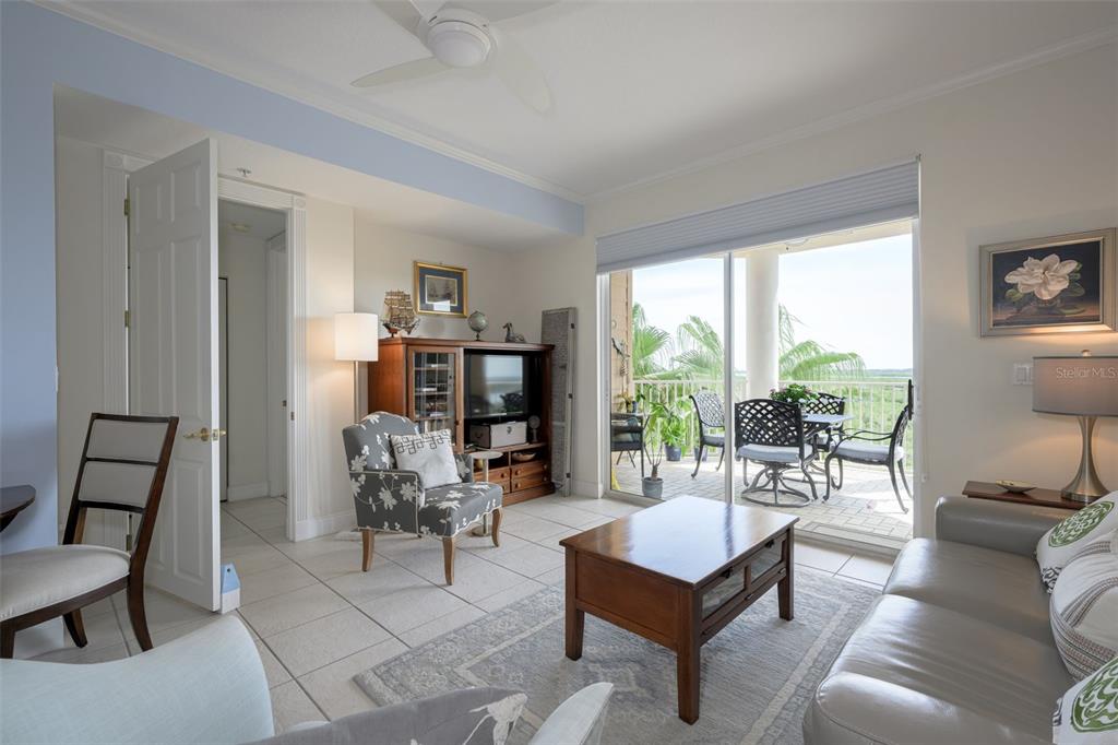 An open-concept living and dining area with tile floors, a balcony, and a bedroom view — 4624 HARBOUR VILLAGE BOULEVARD UNIT 4504, PONCE INLET, FL