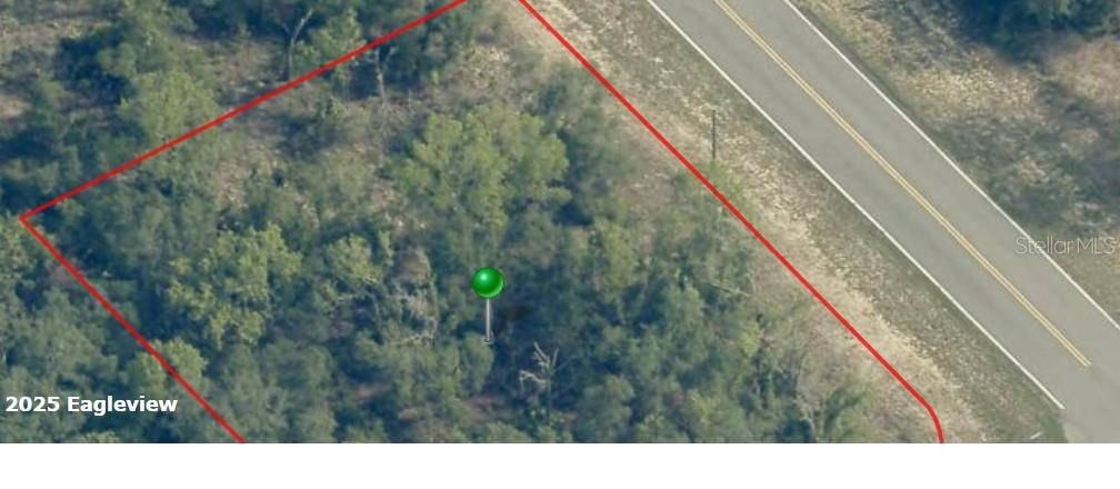 An aerial view shows a wooded plot of land outlined in red next to a road — 1418 W HAMPSHIRE BOULEVARD, CITRUS SPRINGS, FL