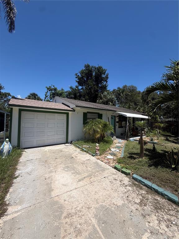 A single-story house with a white exterior, a garage, and a concrete driveway — 811 28TH AVENUE S, ST PETERSBURG, FL