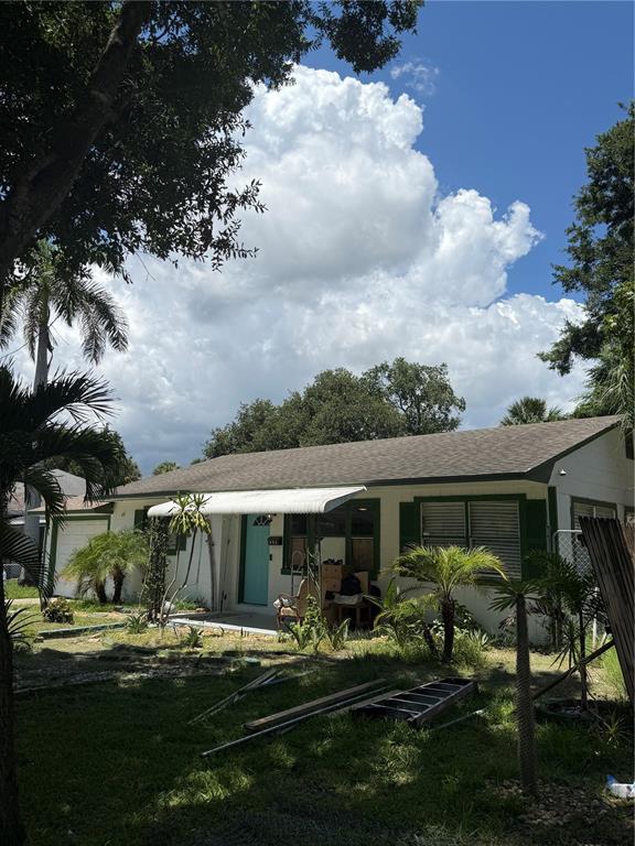 A single-story house with a light-colored exterior, green shutters, and a turquoise front door — 811 28TH AVENUE S, ST PETERSBURG, FL