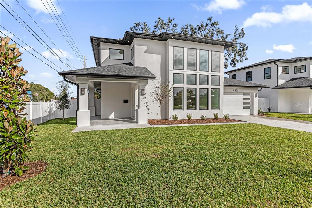 A modern two-story house with white stucco siding, large windows, and a covered front porch — 4401 ROCKLEDGE ROAD, ORLANDO, FL