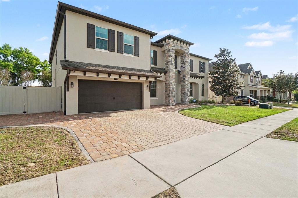 A two-story house features a stone-accented entryway, a paved driveway, and a two-car garage — 17987 GOURD NECK LOOP, WINTER GARDEN, FL