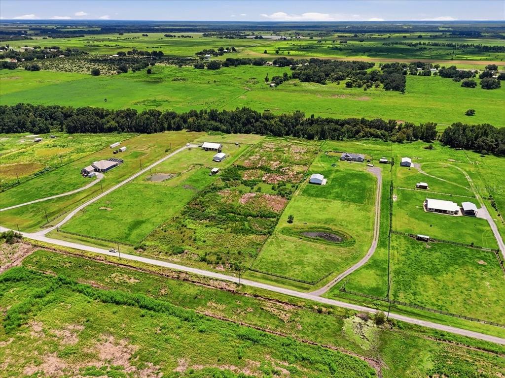 An aerial view shows multiple houses and outbuildings on a large, rural grassy property — 737 BROOKE ROAD, FORT MEADE, FL