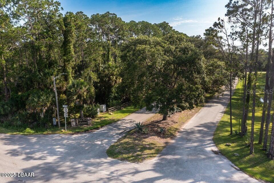 A paved road forks into two paths leading into a wooded area with a sign — 3 REMINGTON ROAD, ORMOND BEACH, FL