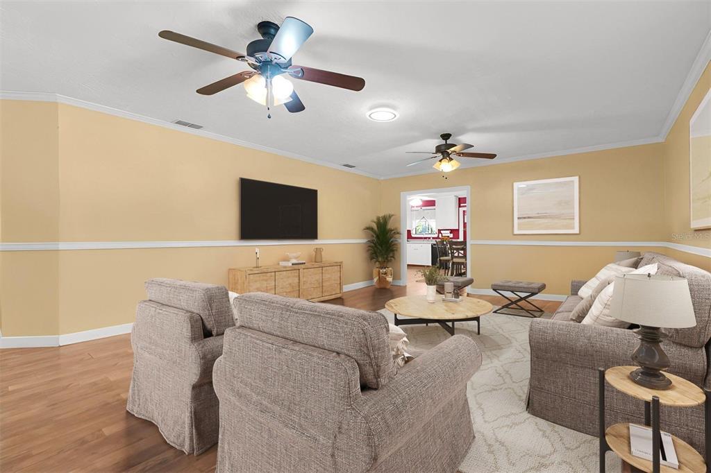 A living room with light yellow walls, two ceiling fans, and beige upholstered furniture — 7224 SHAW RD., BROOKSVILLE, FL