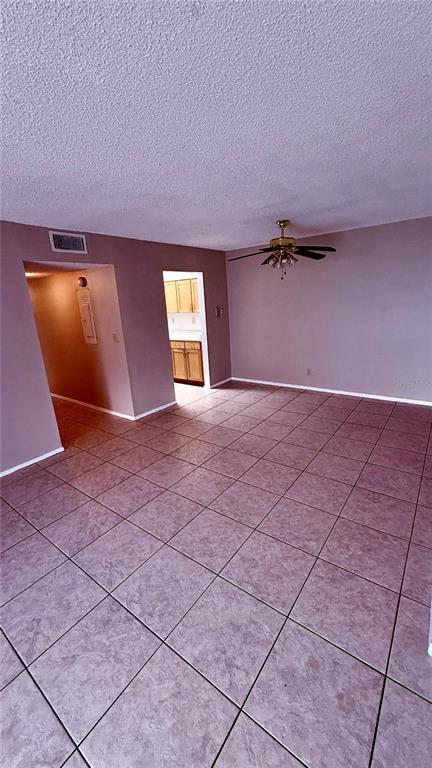 A galley-style kitchen features light wood cabinets, white countertops, and a laundry area at the end — 6519 W NEWBERRY ROAD UNIT 912, GAINESVILLE, FL