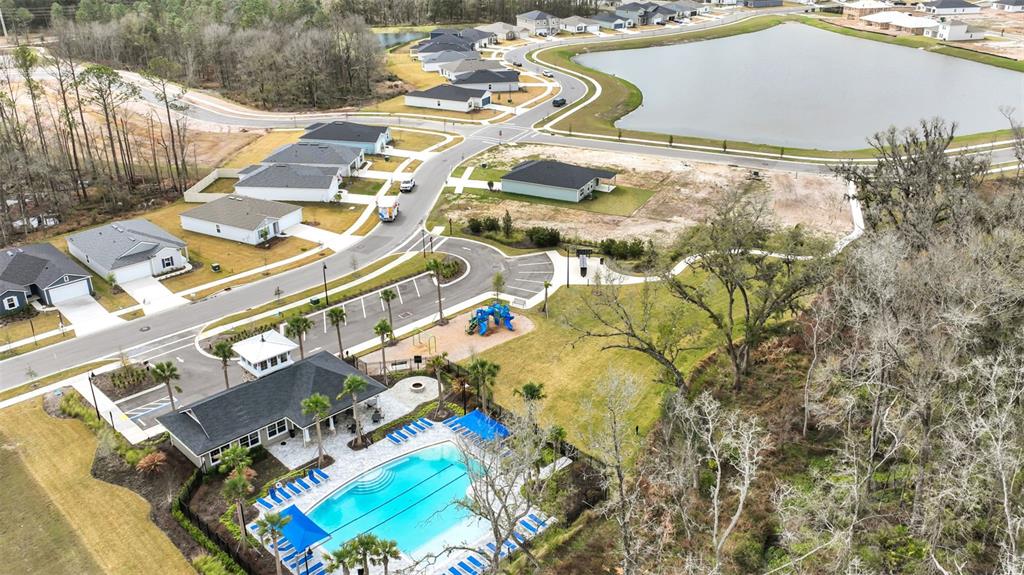 An aerial view shows a community swimming pool, clubhouse, playground, and surrounding residential houses — 3167 GADWALL ROAD, ORANGE PARK, FL