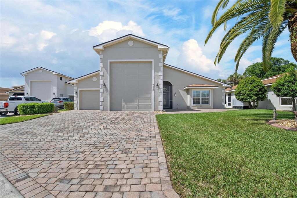 A single-story house with a paved driveway, two garage doors, and a green lawn — 4152 DUNMORE DRIVE, LAKE WALES, FL