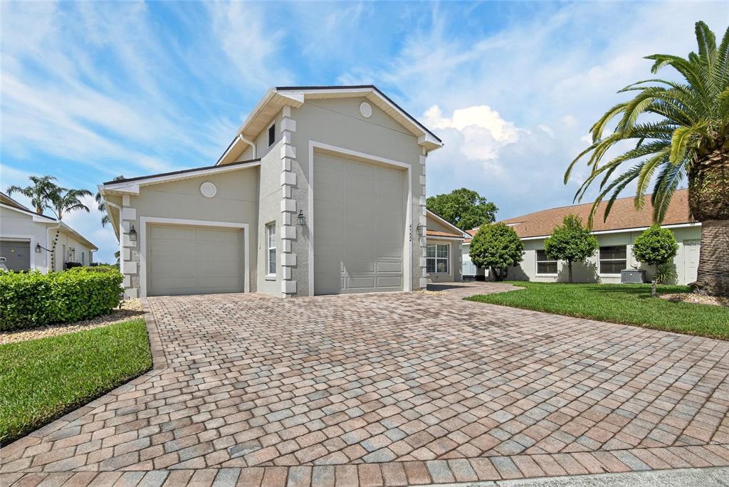 A house exterior features a tall RV garage door, a standard garage, and paver driveway — 4152 DUNMORE DRIVE, LAKE WALES, FL