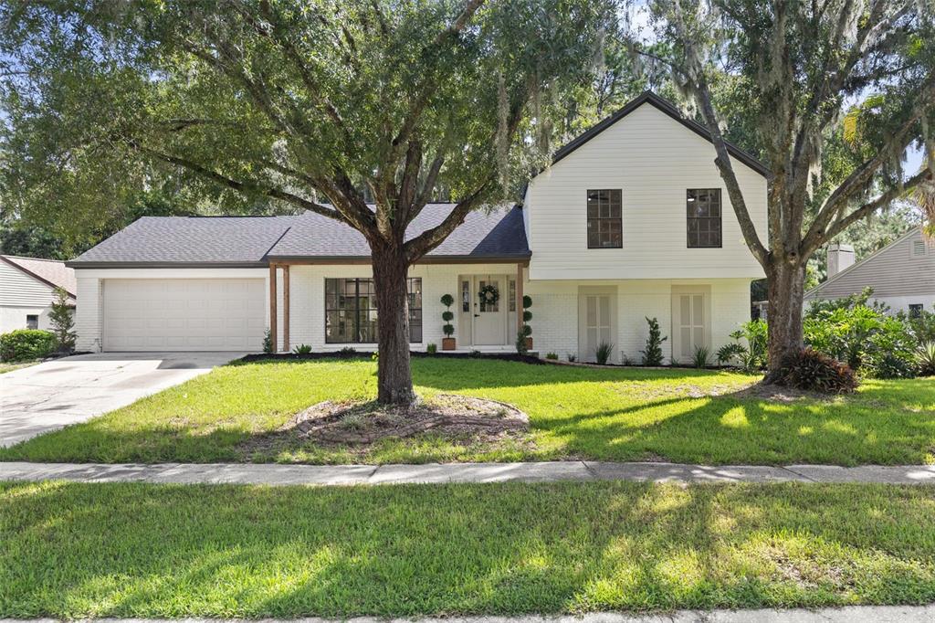 A two-story white house with a garage, large trees, and a front lawn — 3720 MURRAY DALE DRIVE, VALRICO, FL