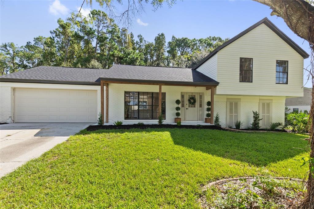 A two-story house with white brick and siding, a garage, and a covered front porch — 3720 MURRAY DALE DRIVE, VALRICO, FL