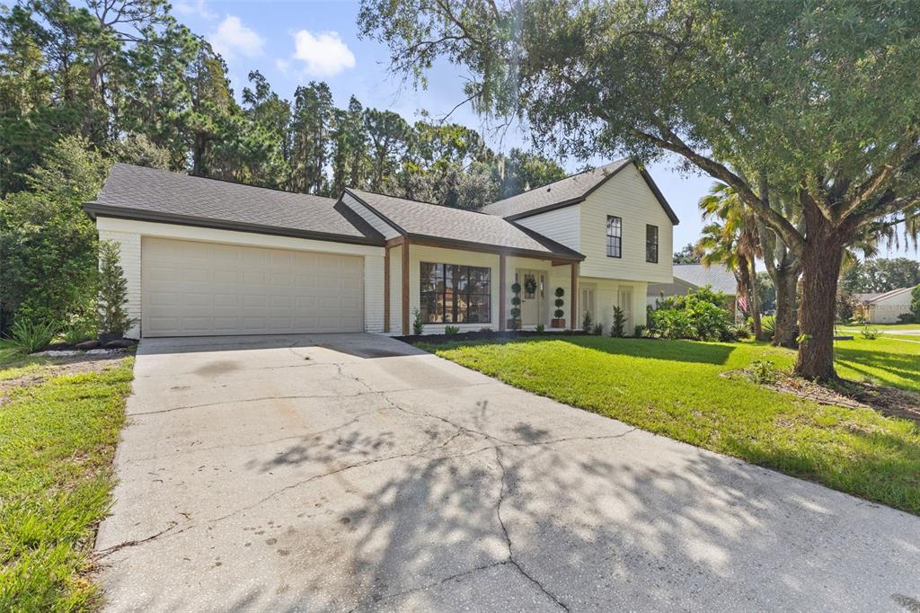 A two-story house with a white exterior, a two-car garage, and a cracked concrete driveway — 3720 MURRAY DALE DRIVE, VALRICO, FL