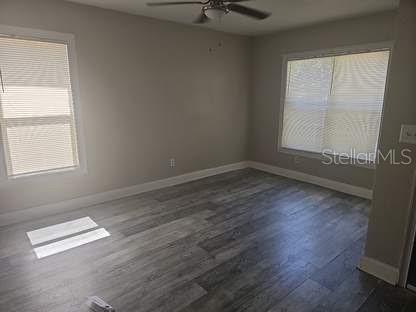 An empty bedroom features light gray walls, wood-look flooring, a ceiling fan, and two windows — 225 1ST STREET, WINTER GARDEN, FL