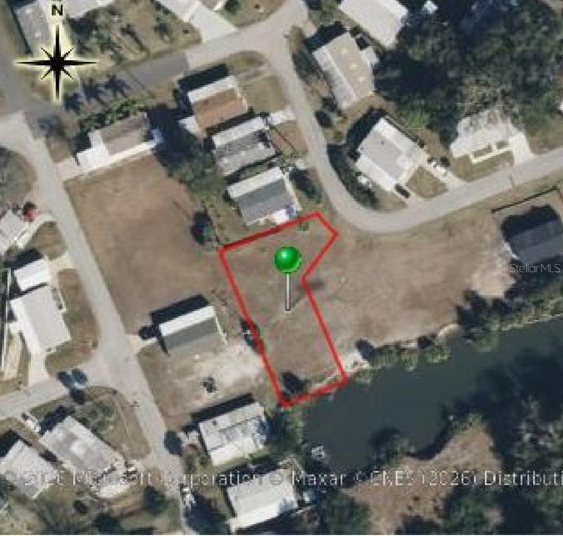 An aerial view shows a vacant, irregularly shaped residential lot outlined in red near water — 4366 WHITING WAY, EDGEWATER, FL