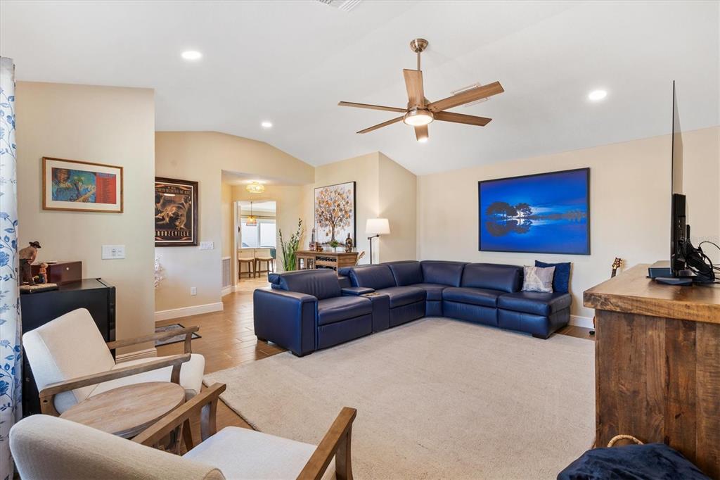 A living room features a blue sectional sofa, two armchairs, and a ceiling fan — 1026 SMYRNA STREET, THE VILLAGES, FL