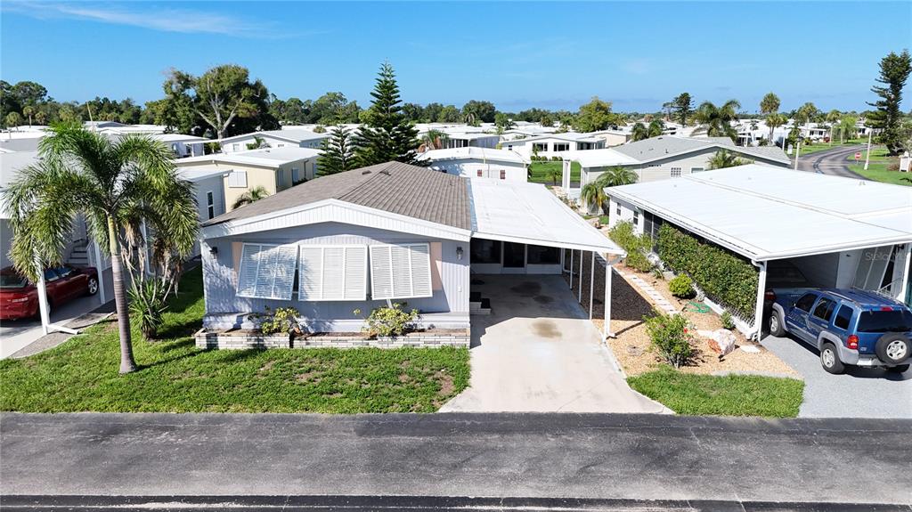 An aerial view shows a light-colored manufactured home with a carport and a palm tree — 3 S BUENA VISTA AVENUE, ENGLEWOOD, FL