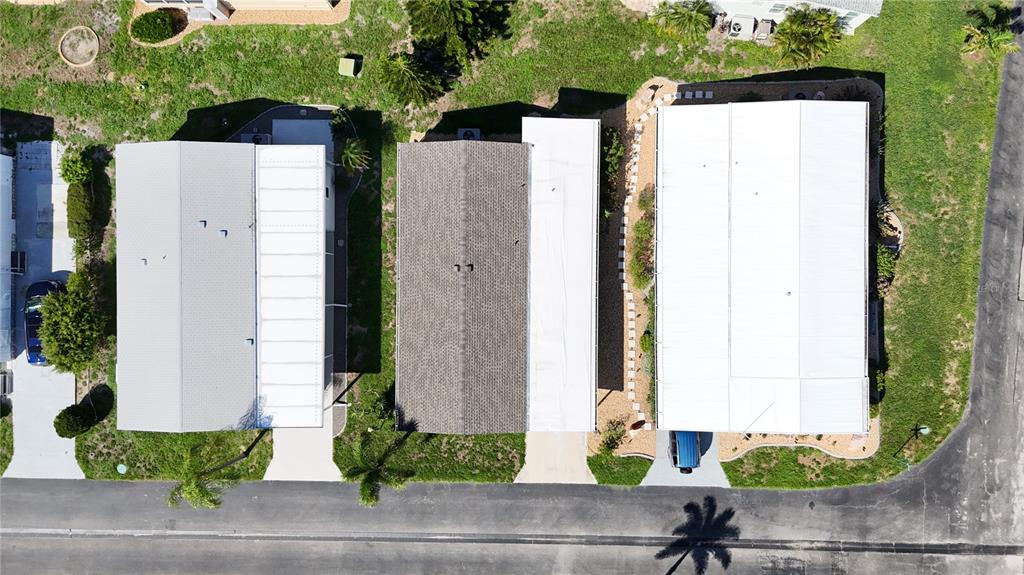 An aerial view shows three adjacent manufactured homes with white roofs and paved driveways — 3 S BUENA VISTA AVENUE, ENGLEWOOD, FL