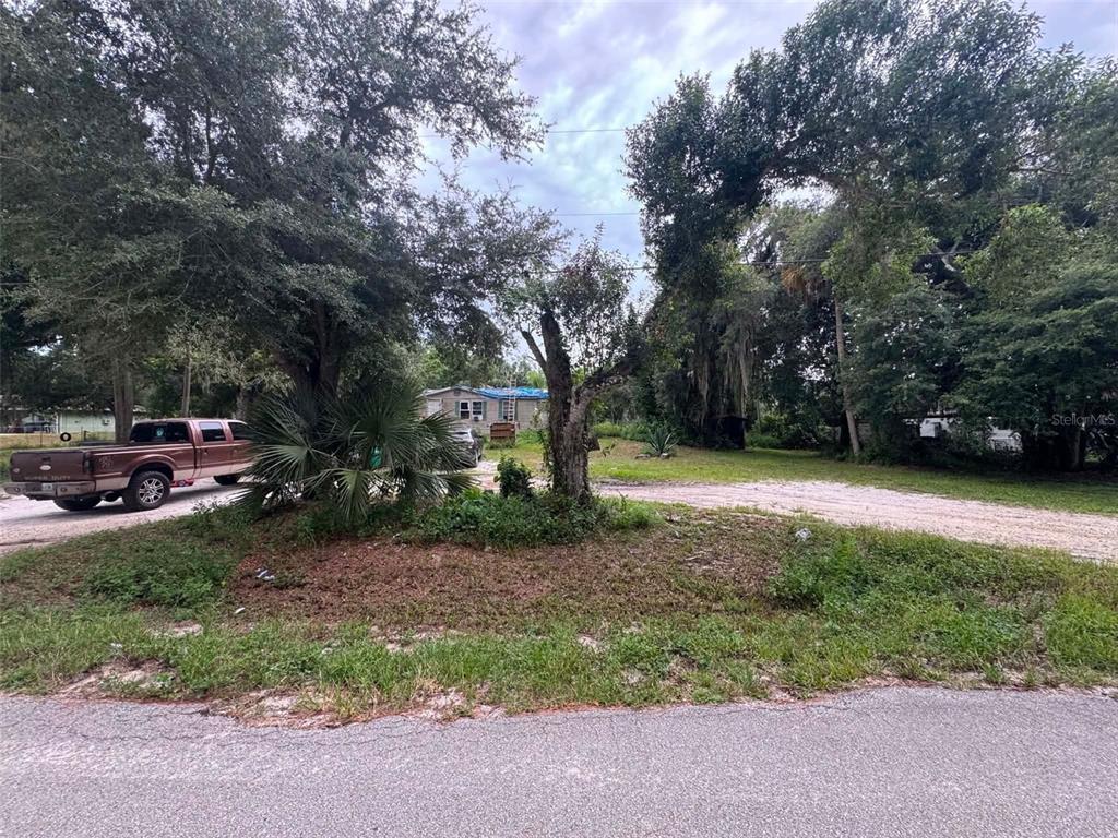 A brown pickup truck is parked on a dirt driveway in front of a house — 6702 NE 1ST STREET, OKEECHOBEE, FL