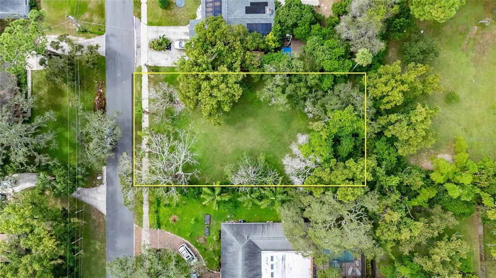 An aerial view shows a rectangular vacant lot surrounded by mature trees and residential properties — 5208 E 122ND AVENUE, TEMPLE TERRACE, FL