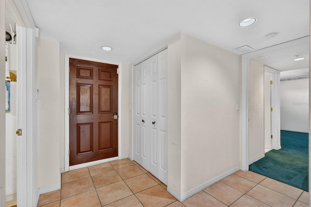 An entryway features a brown front door, white bifold closet doors, and light-colored tile flooring — 1 JOHN ANDERSON DRIVE UNIT 5150, ORMOND BEACH, FL