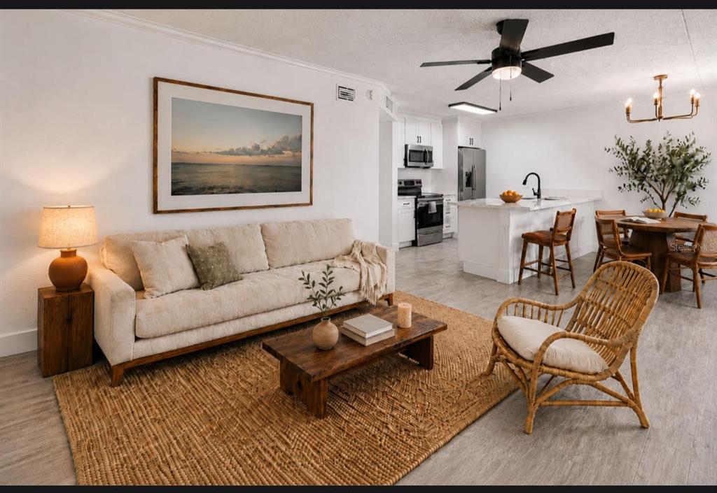 A waterfront patio features a picnic table with an umbrella, a bench, and two outdoor grills — 10375 PARADISE BOULEVARD UNIT 51, TREASURE ISLAND, FL