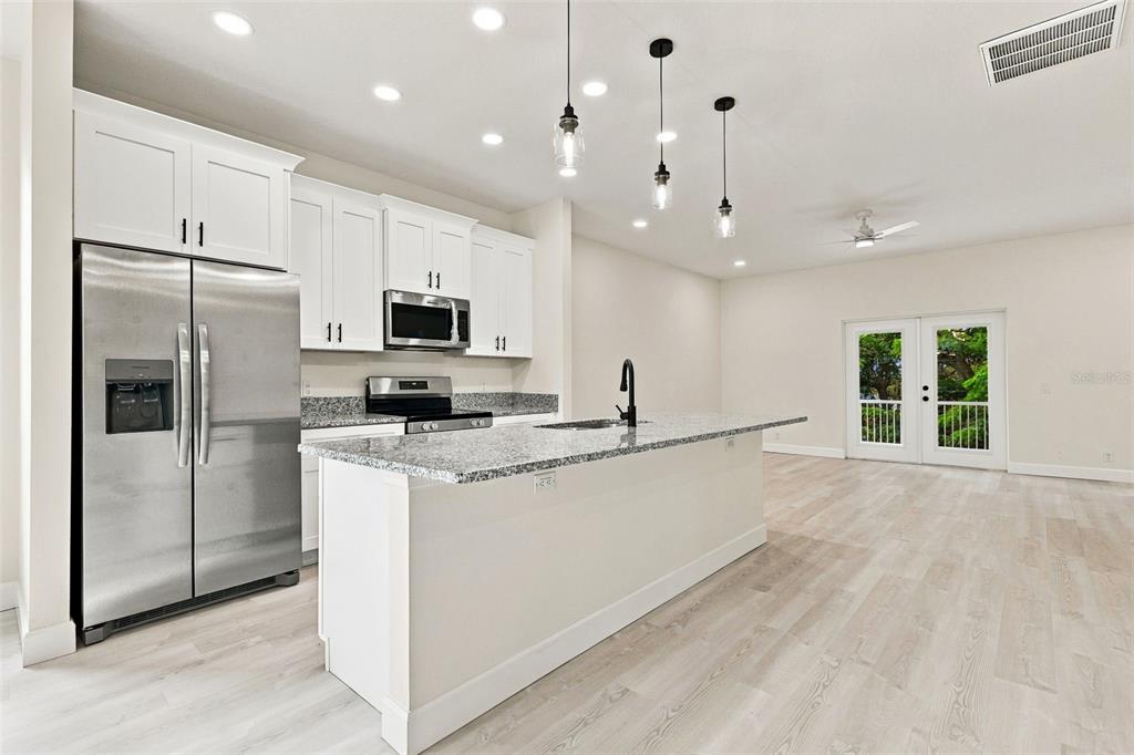 An unfinished room with white walls, a partial partition wall, and glass double doors — 537 PINELOCH DRIVE, HAINES CITY, FL