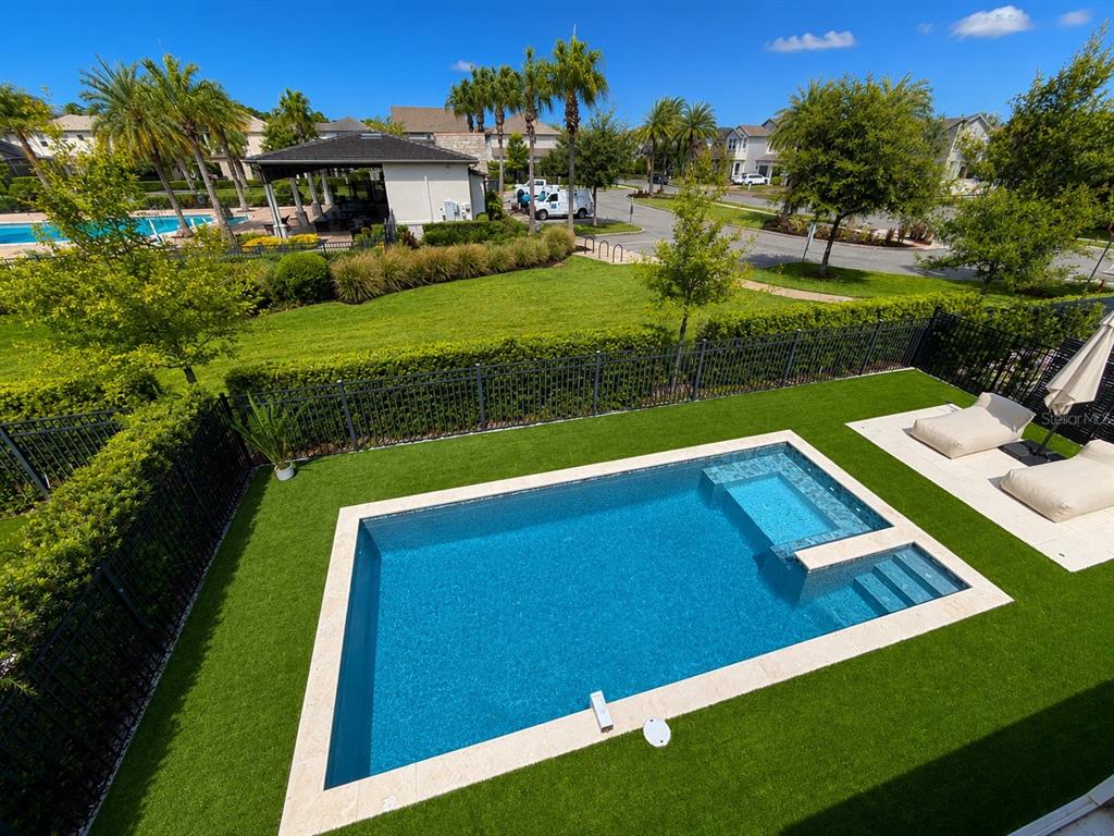 An elevated view of a rectangular backyard pool with a tanning ledge and artificial turf — 12989 WESTSIDE VILLAGE LOOP, WINDERMERE, FL