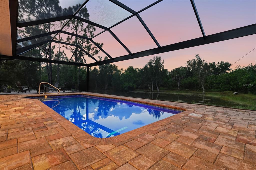 A modern kitchen features white cabinets, stainless steel appliances, and a wood-toned center island — 6000 CLEVELAND DRIVE, PUNTA GORDA, FL