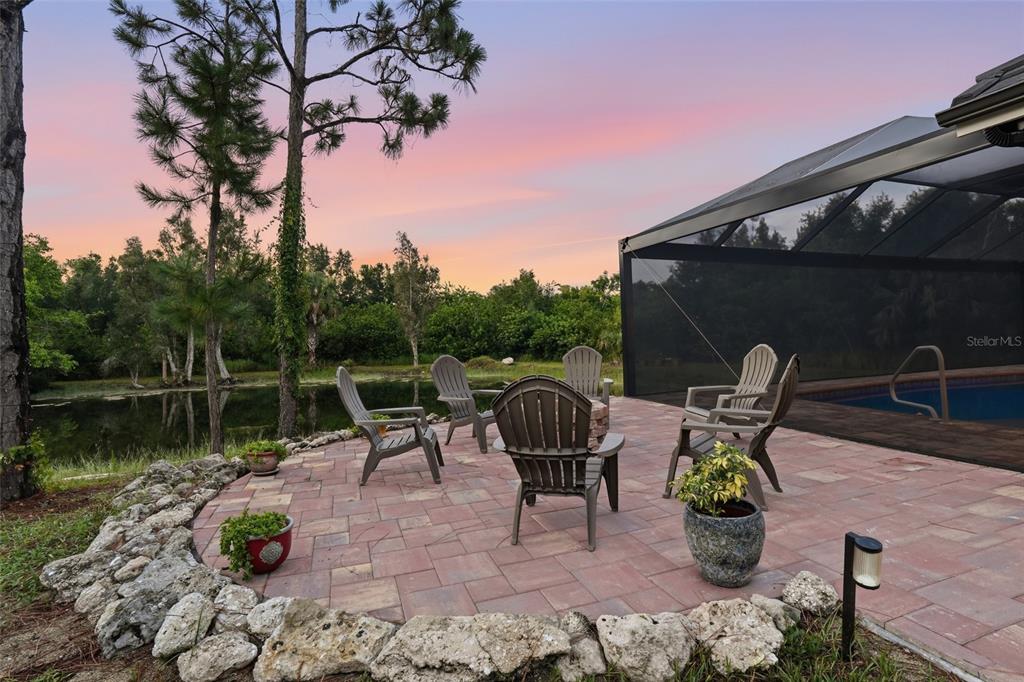 A screened-in patio features a swimming pool with a sun shelf and a brick paver deck — 6000 CLEVELAND DRIVE, PUNTA GORDA, FL
