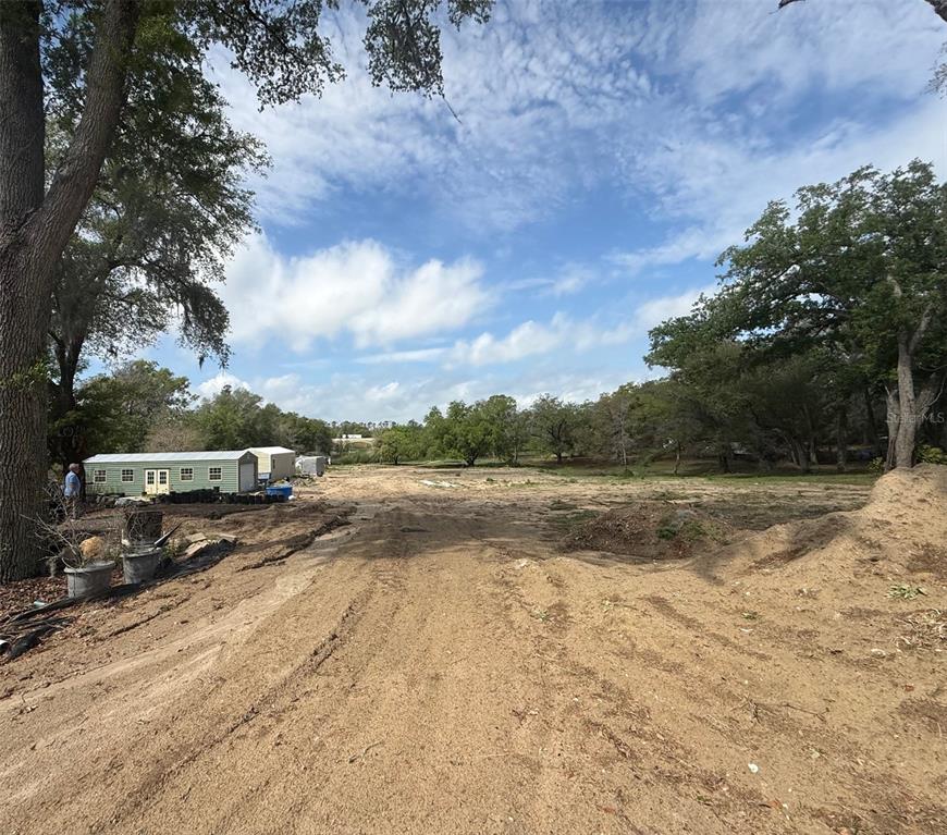 A dirt path leads through a cleared, wooded lot with a small shed on the left — 3330 PLYMOUTH SORRENTO ROAD, APOPKA, FL
