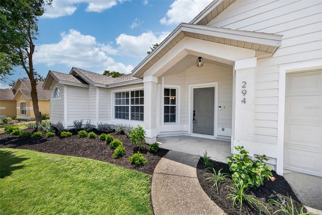 An open-concept living and dining area features light wood-look flooring and a modern kitchen — 294 LAKE DOE BOULEVARD, APOPKA, FL