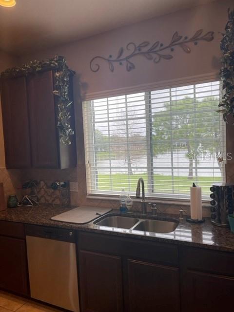 A kitchen features dark wood cabinets, a double sink, and a window overlooking a lake — 2526 PASSAMONTE DRIVE UNIT 10F, WINTER PARK, FL