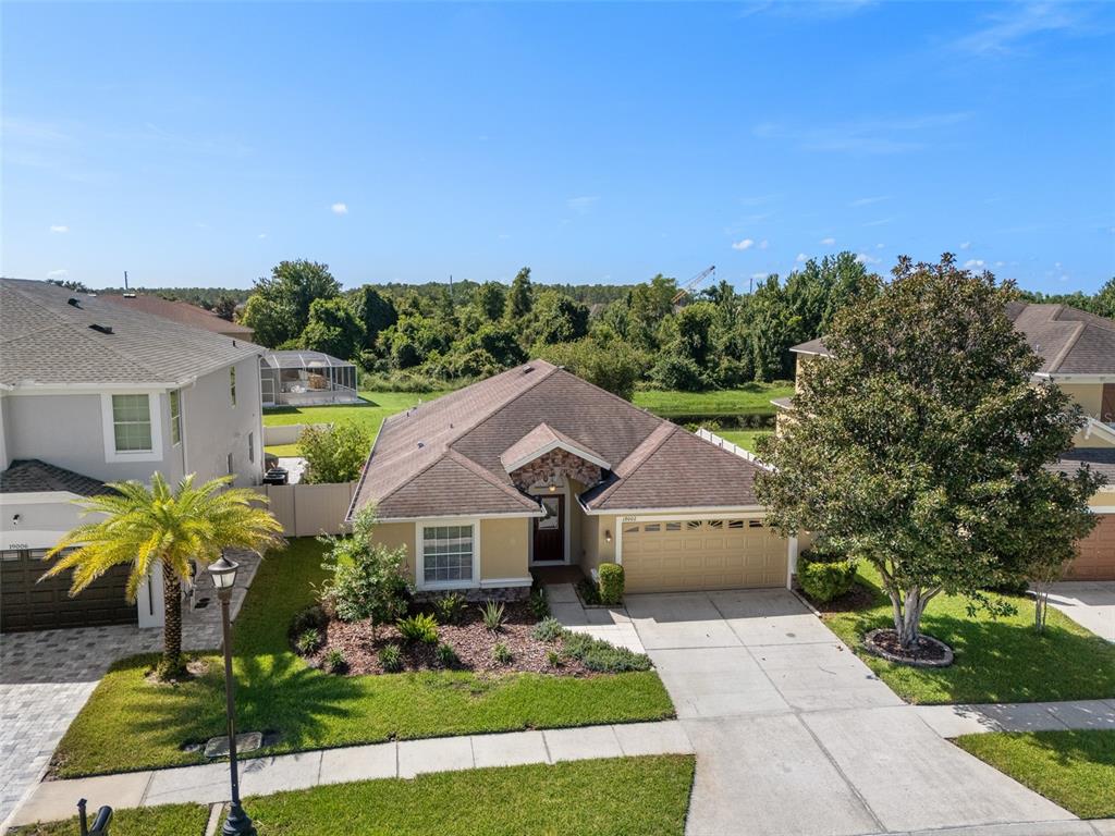 An aerial view of a single-story suburban house with a driveway and front landscaping — 19002 NARIMORE DRIVE, LAND O LAKES, FL