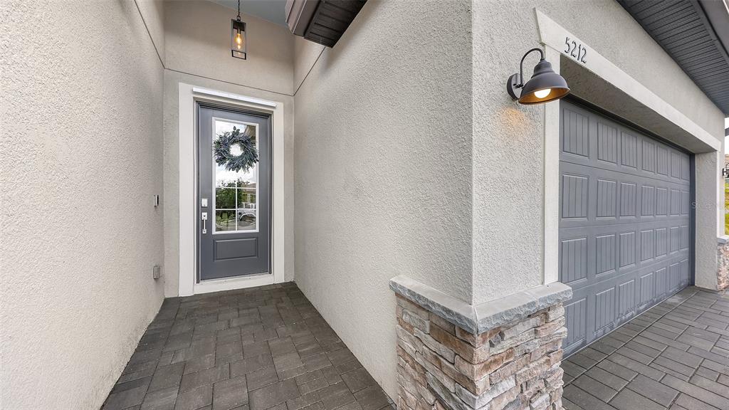 A gray front door and garage door are set against a beige stucco exterior wall — 5212 MARINA BASIN COURT, BRADENTON, FL