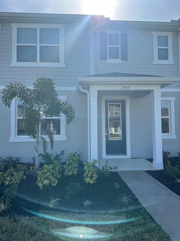 A kitchen with white cabinets, a breakfast bar, and wood-look flooring in an open space — 11459 SUNSAIL AVENUE, ORLANDO, FL