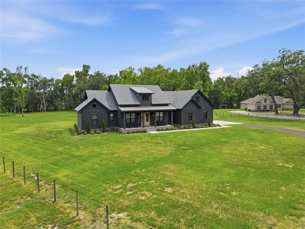 A dark-sided farmhouse with a gray roof sits on a large, grassy rural lot — 2398 GEORGE WHEELER ROAD, LAKELAND, FL