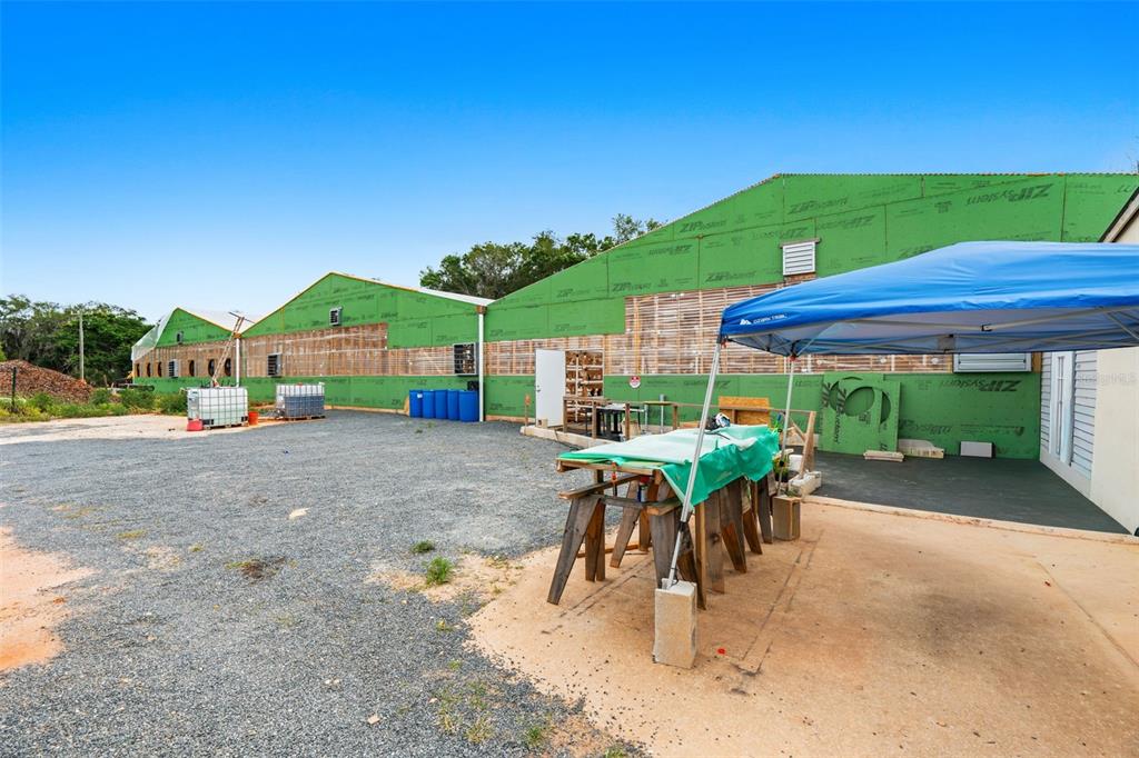 An exterior view of a building under construction with green sheathing and a blue canopy — 3510 WALK IN WATER ROAD, LAKE WALES, FL