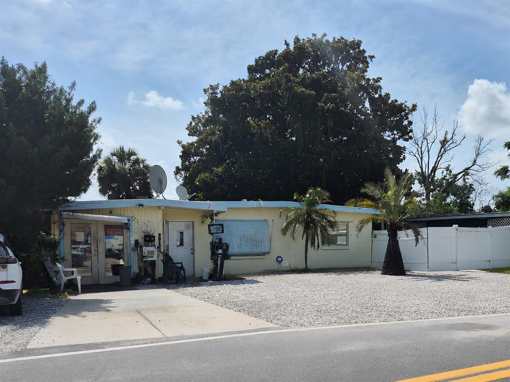 A single-story yellow building with a gravel front yard and a palm tree — 4007 FLAMINGO DRIVE, NEW PORT RICHEY, FL
